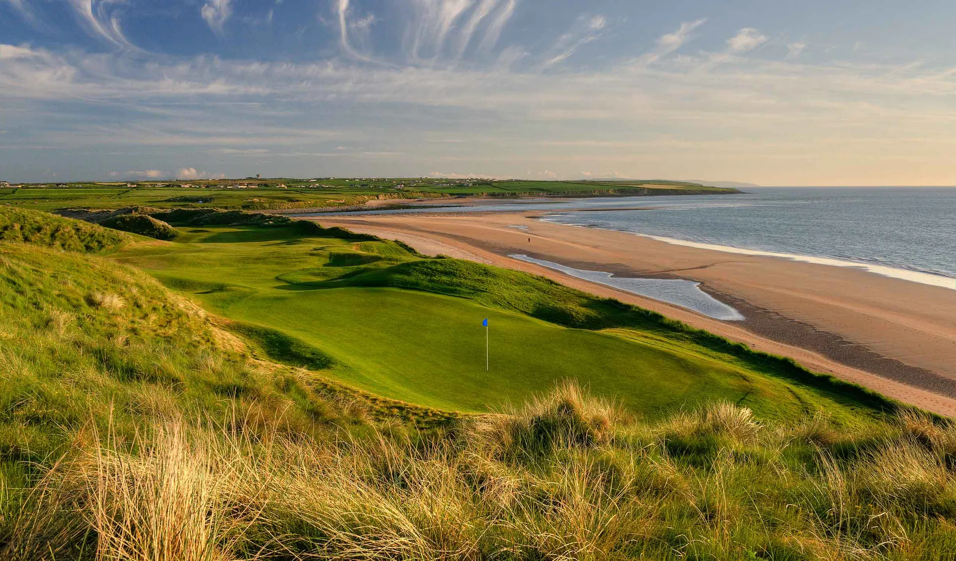 The seventh green on Ballybunion’s Cashen Course among dunes beside the Atlantic beach.