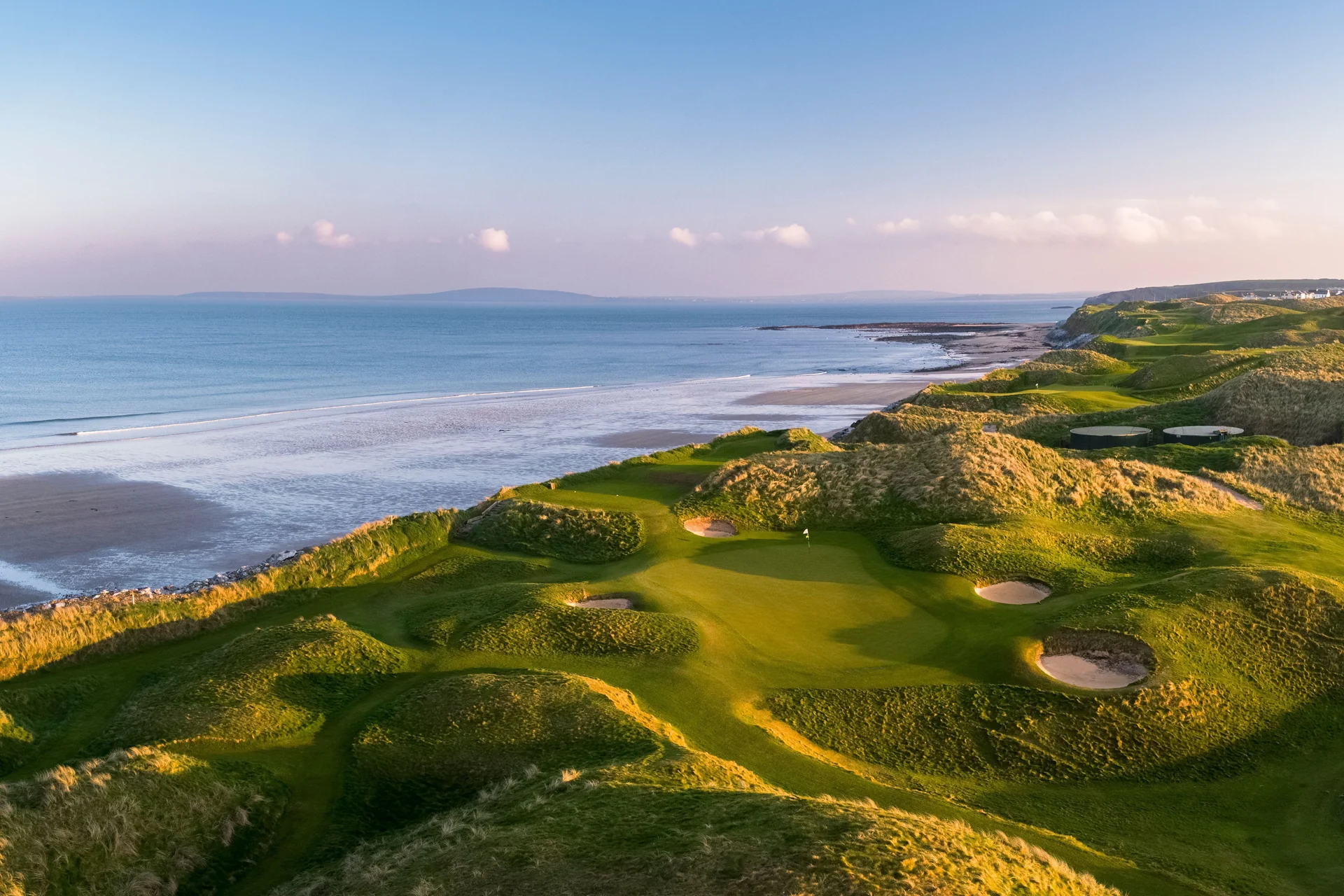 Greens and bunkers among coastal dunes beside the Atlantic at Ballybunion Old Course.